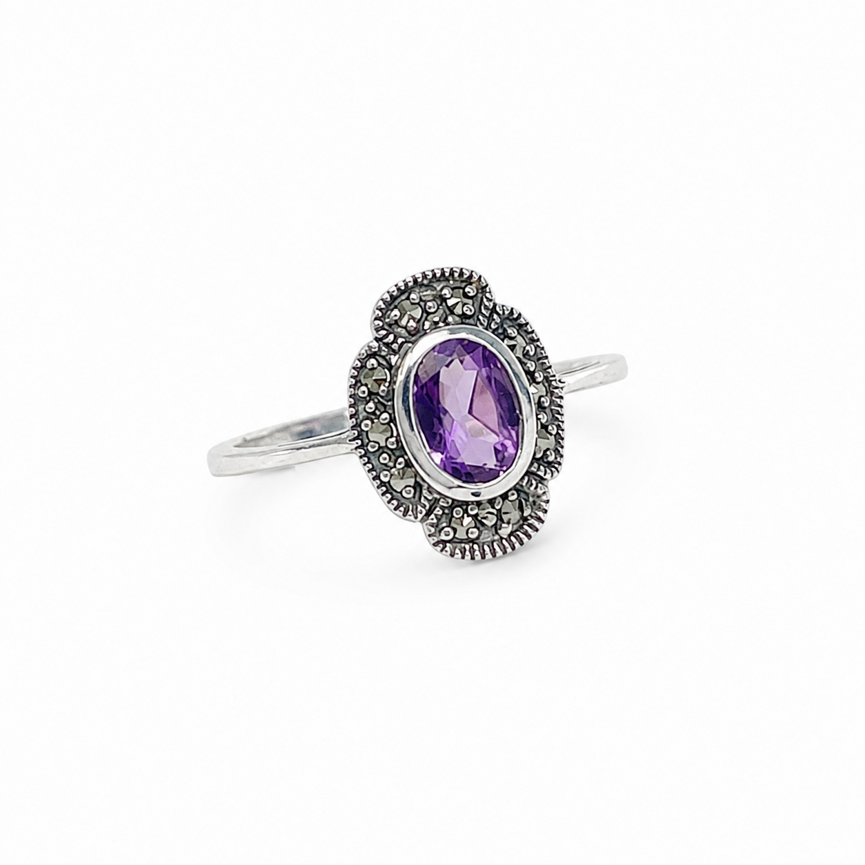 Silver ring with a purple gemstone on a white background
