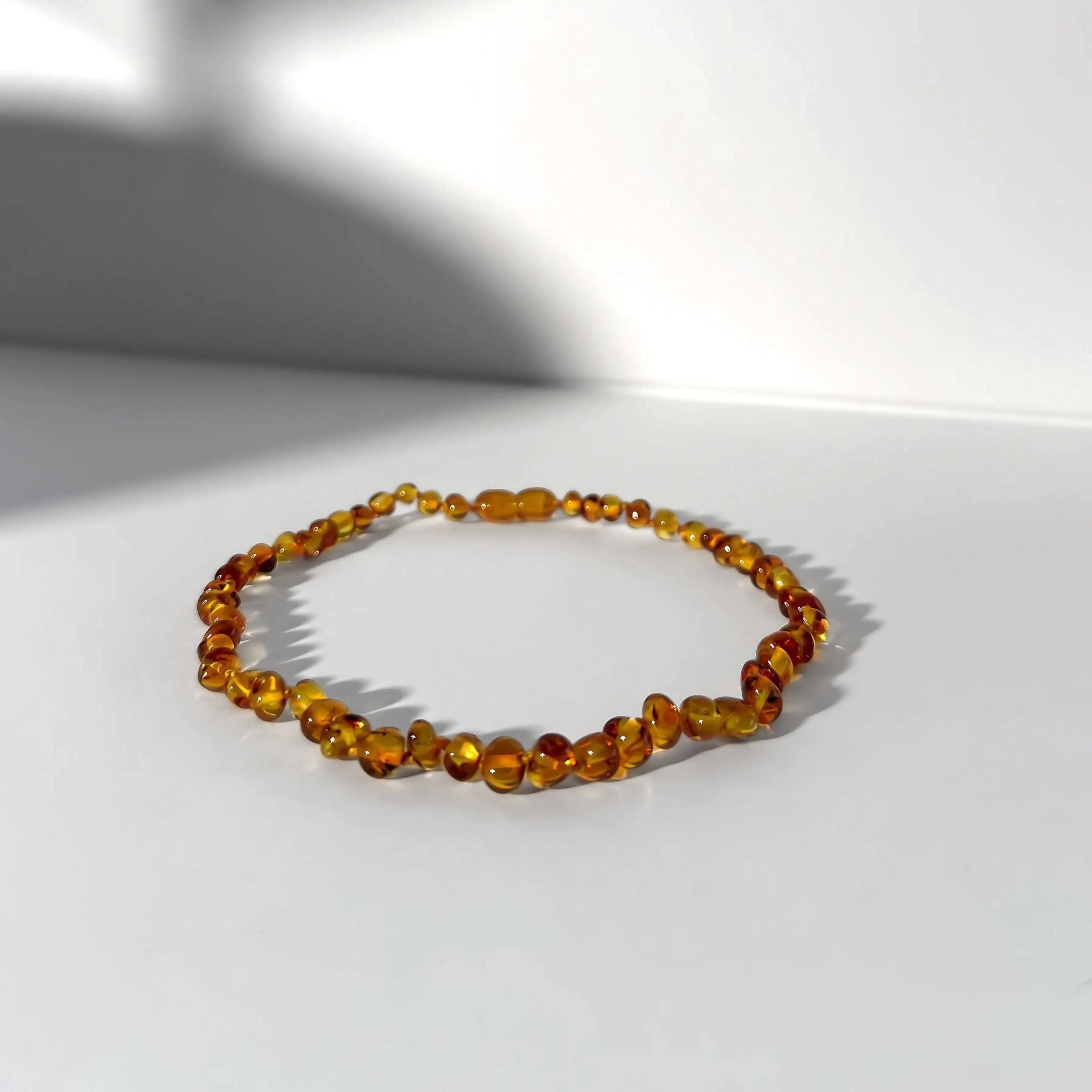 Beaded bracelet on a white surface with a soft shadow