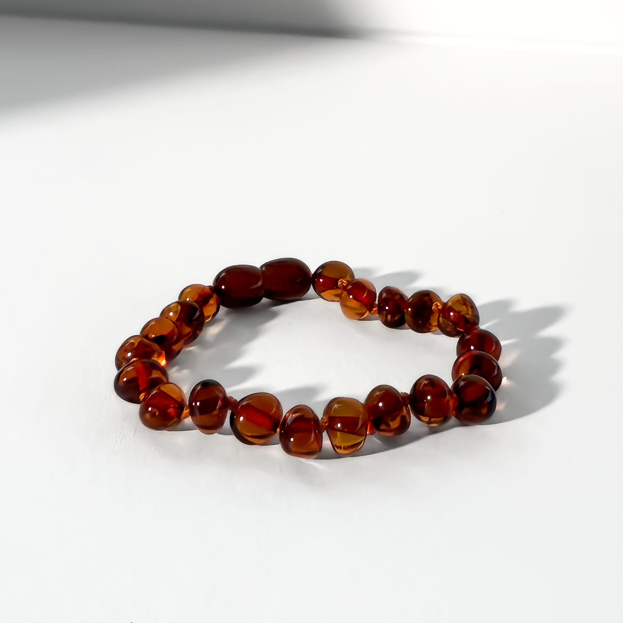 Beaded bracelet with brown and red beads on a white background