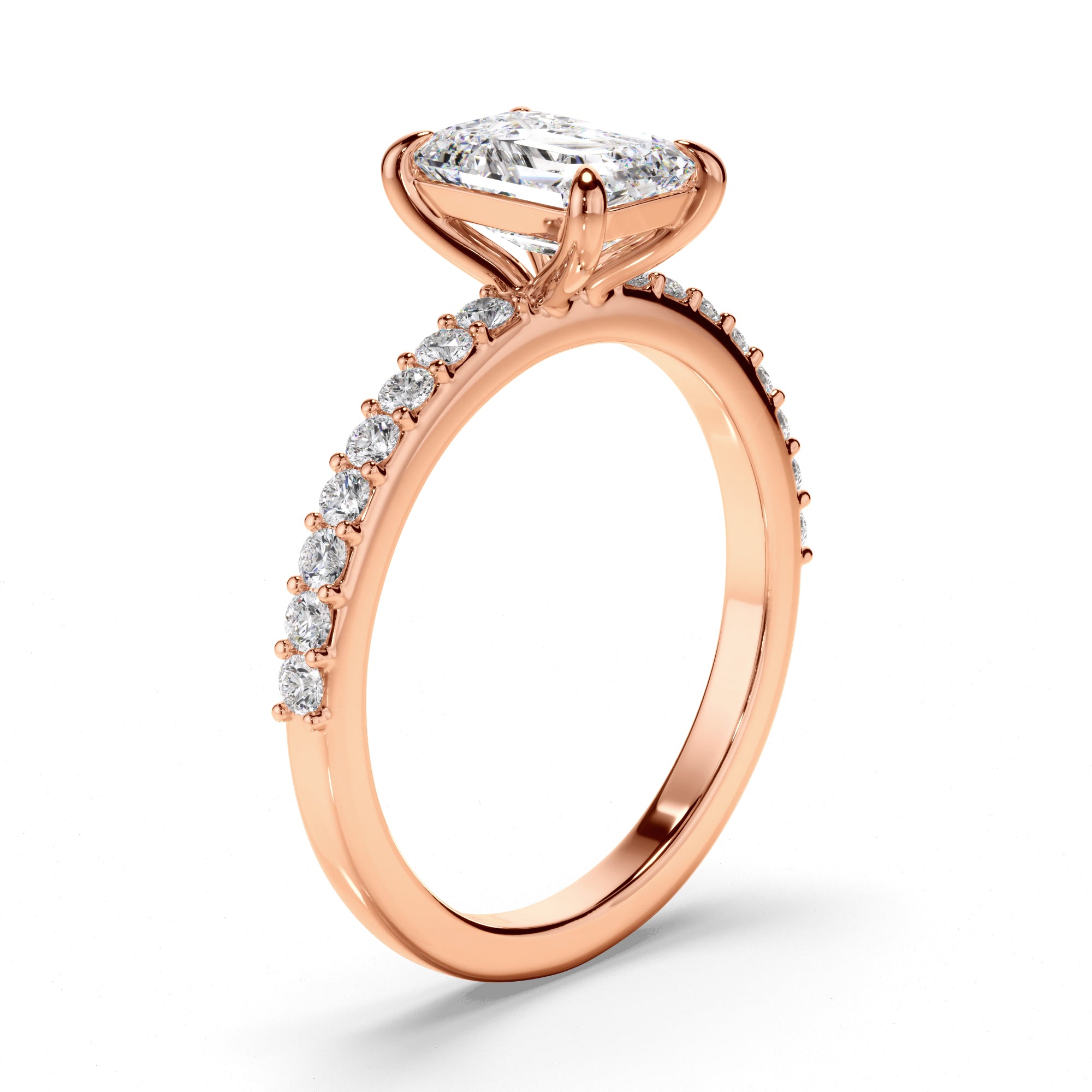 Rose gold ring with emerald centre stone and pave diamonds on a white background