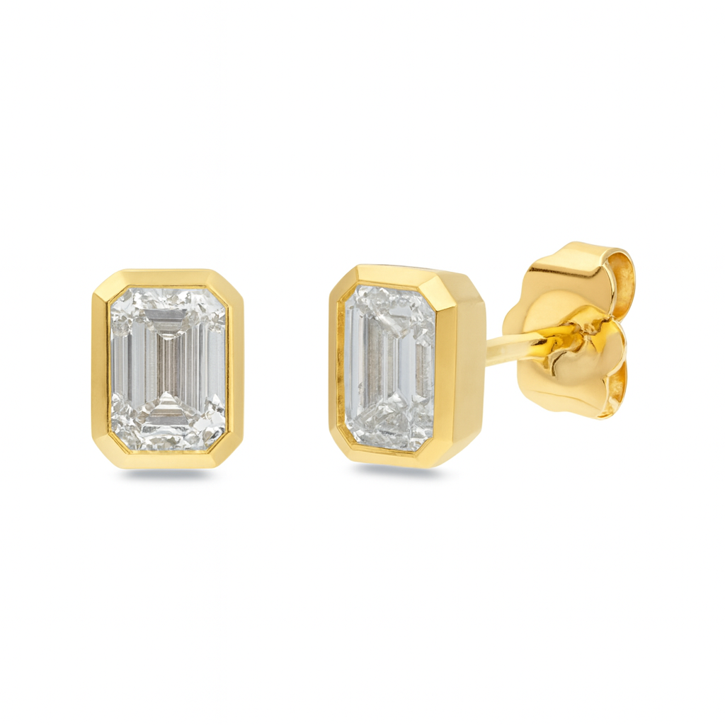 Gold earrings with emerald-cut gemstones on a white background