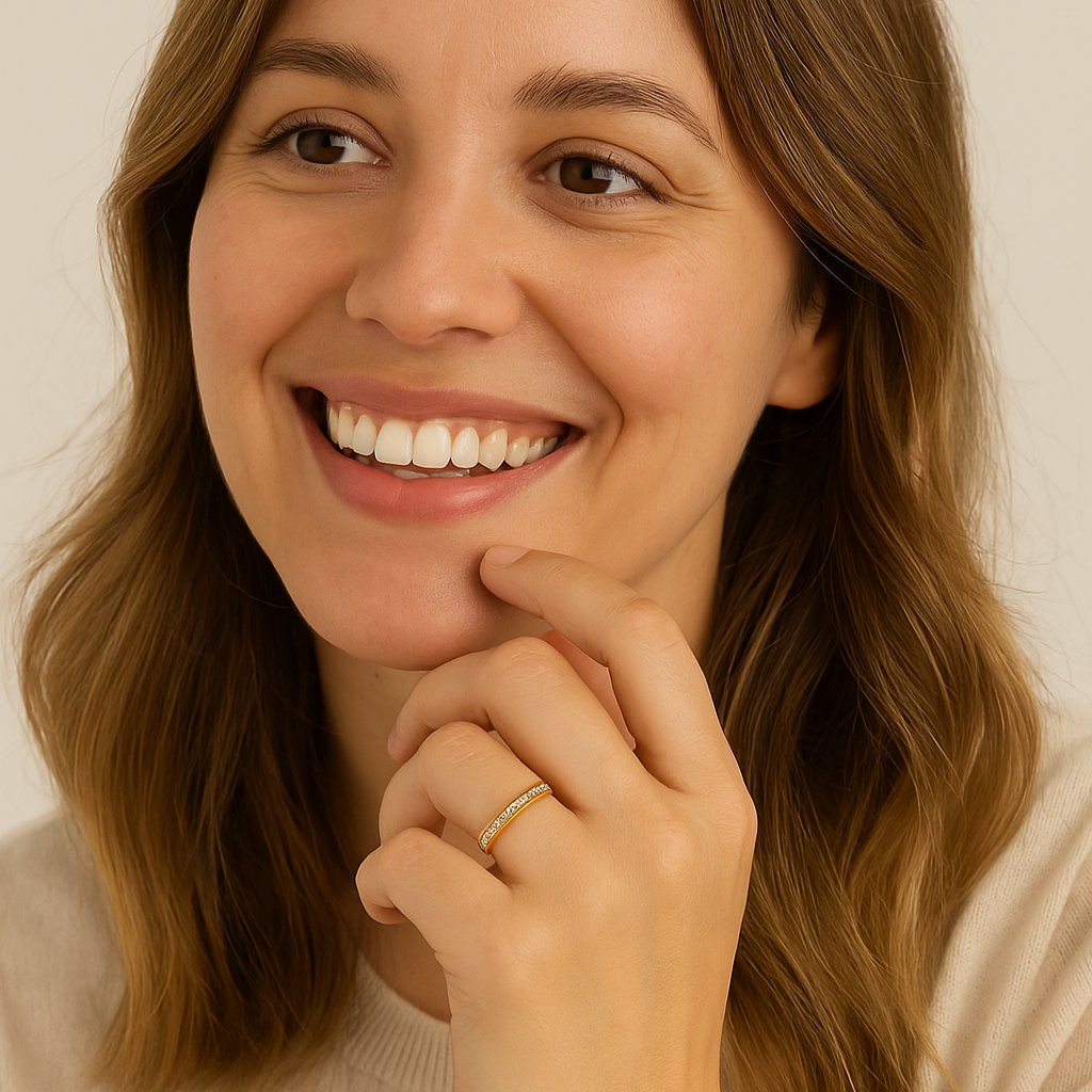 Woman with a warm smile and hand near her face against a neutral background