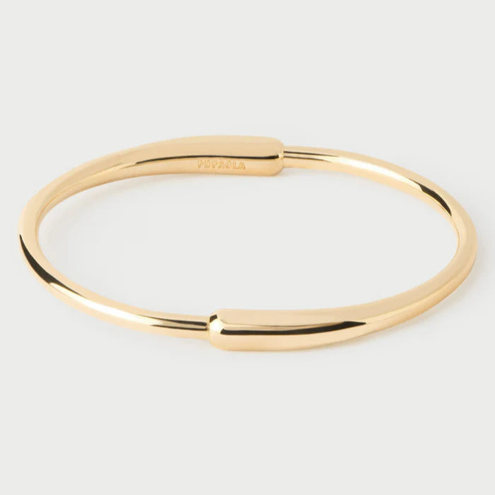 Gold bangle on a light gray background