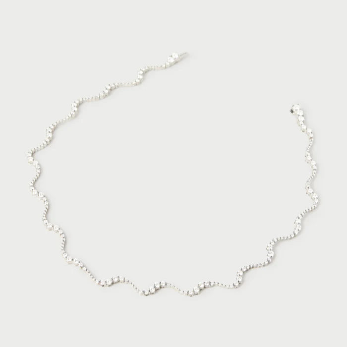 Delicate silver necklace on a light gray background