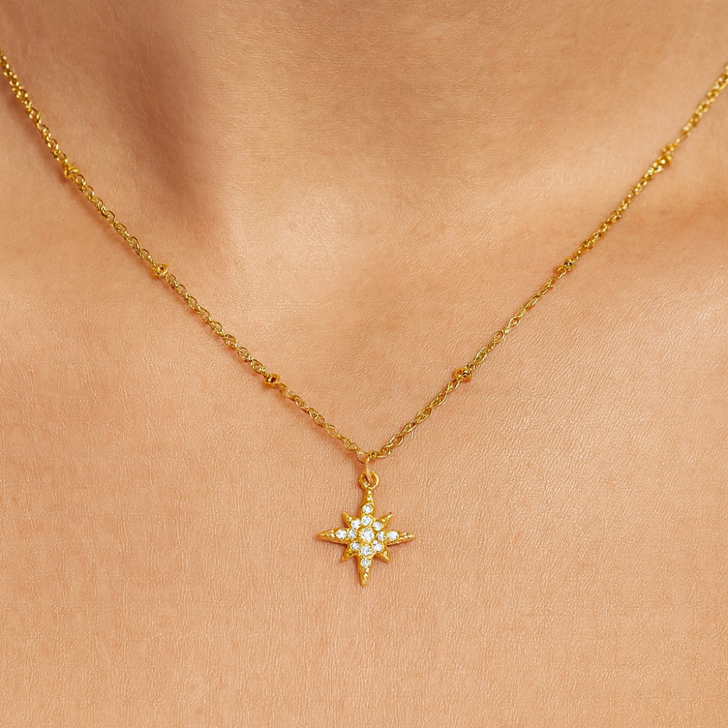 Gold necklace with a star-shaped pendant on a person's neck