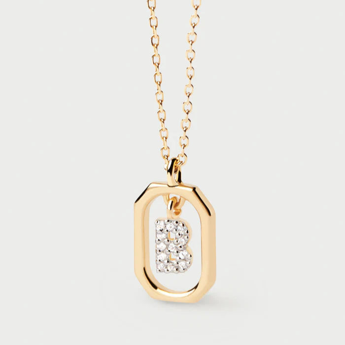 Gold necklace with a diamond pendant on a light gray background