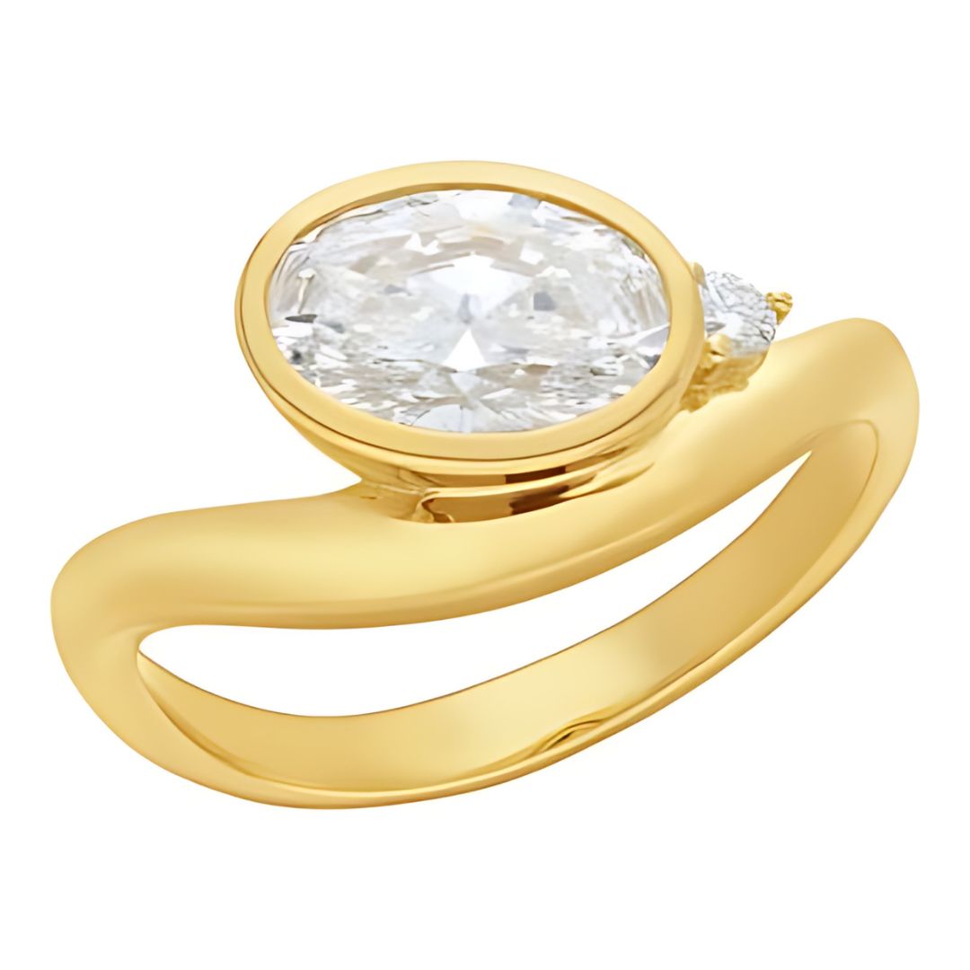 Gold ring with a large diamond and smaller gemstone on a white background